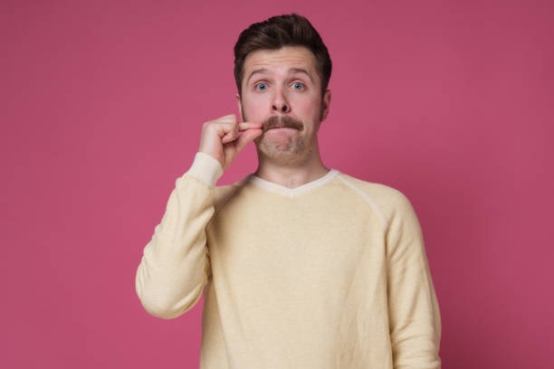 istock man with mustache, making gesture with hand, zipping lips, promising to keep secret 1256846247