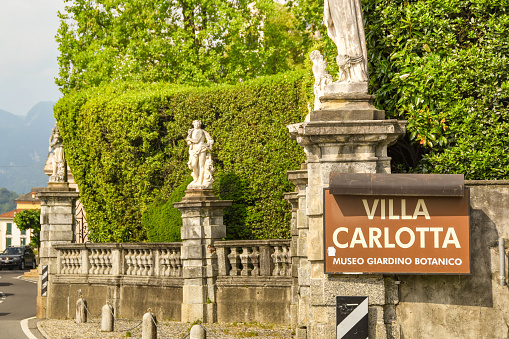 Tremezzo, Lake Como, Italy - June 2019: Sign outside the entrance to the Villa Carlotta in Tremezzo on Lake Como. The villa houses a museum and botanical gardens.