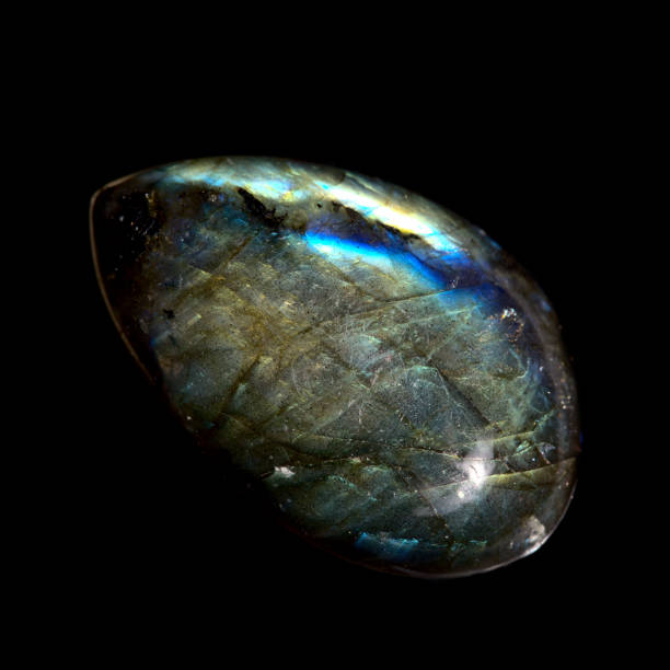 Labradorite teardrop cabochon isolated on black Labradorite teardrop cabochon isolated on black feldspar stock pictures, royalty-free photos & images