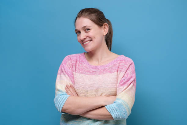 istock Funny cute smiling woman on blue background 1256848011