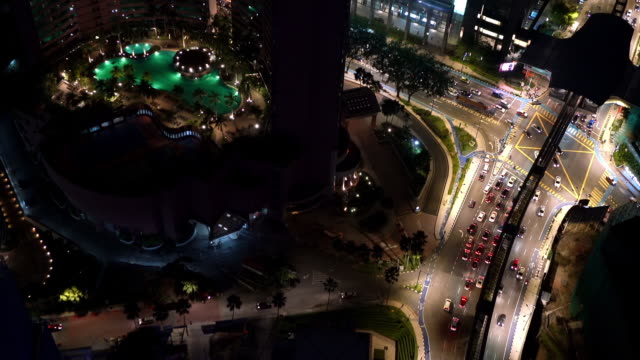 Aerial real-time footage of city traffic moving swiftly by night streets of Kuala Lumpur