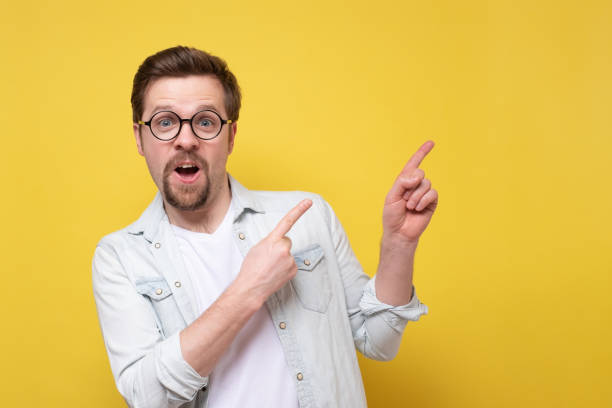 istock Caucasian young man wearing suit smiling and pointing finger aside 1256851281