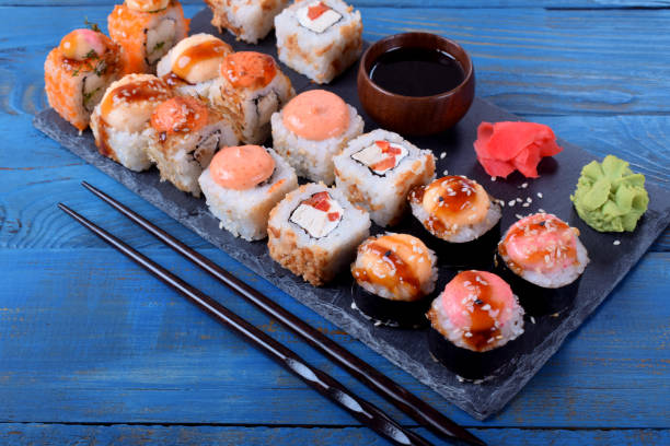 istock Sushi rolls assortment served on slate plate and chopsticks 1256853035