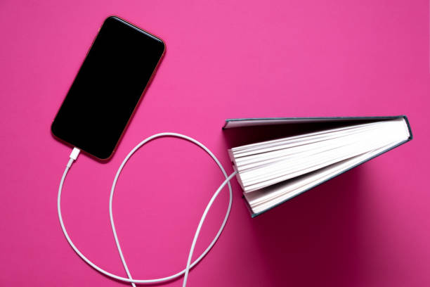 istock Smart phone connected to the old book with a cable, and download information from there 1256853843