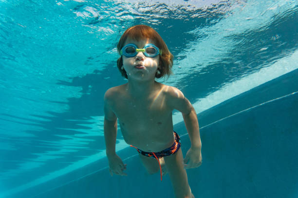 istock Little child swim underwater in pool 1256855138