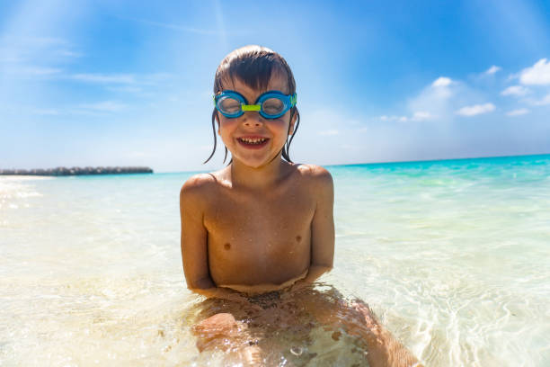 istock Happy boy is playing in the sea 1256855568