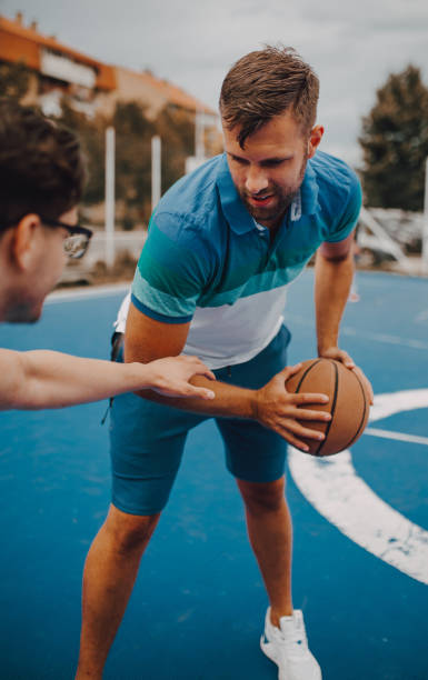 istock Two friends play basketball 1256855615