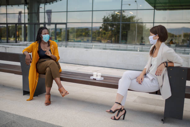 istock Businesswomen talking outdoors with social distancing 1256855730