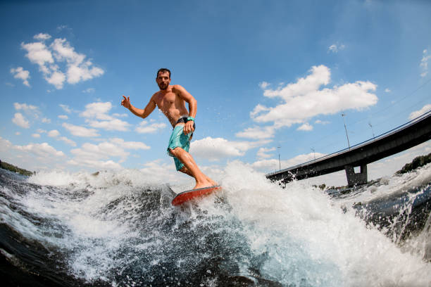 istock wakesurfer balancing on board on wave against blue sky 1256857318