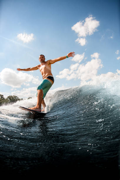 istock view of man on surfboard who is actively riding up the wave 1256858102