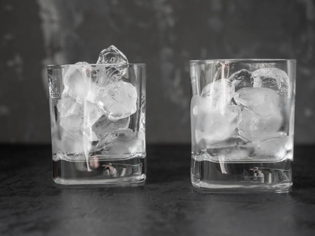 istock Two glasses with ice cubes on a dark background 1256858705