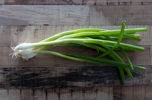 Spring onions on wooden table