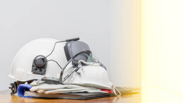istock PPE (Personal Protective Equipment) for  work safety consist with White safety helmet (hard hat) with ear muff attached,Respiratory protection, leather glove, glasses on wooden table. Industrial theme 1256859843
