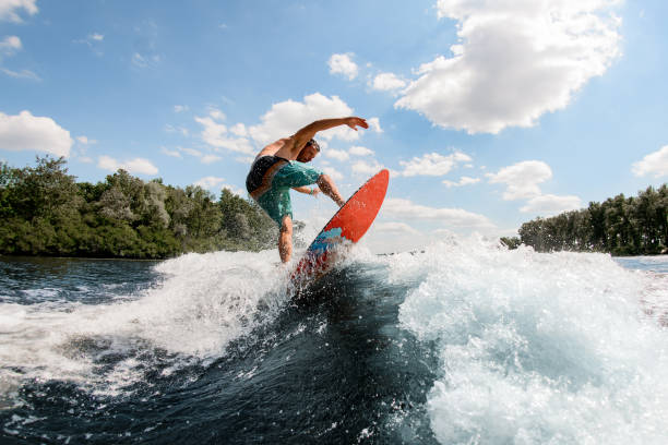 ragazzo attivo che salta sulle onde del fiume - wakeboarding surfing men vacations foto e immagini stock