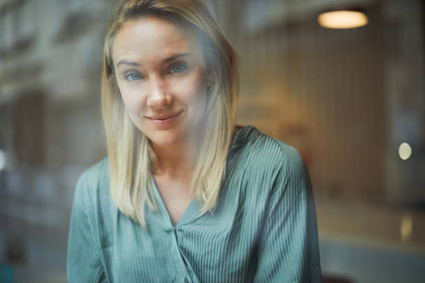istock Woman looking at camer from inside a coffee shop. 1256865354