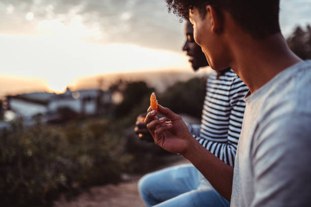 Friend sitting and sharing fruit