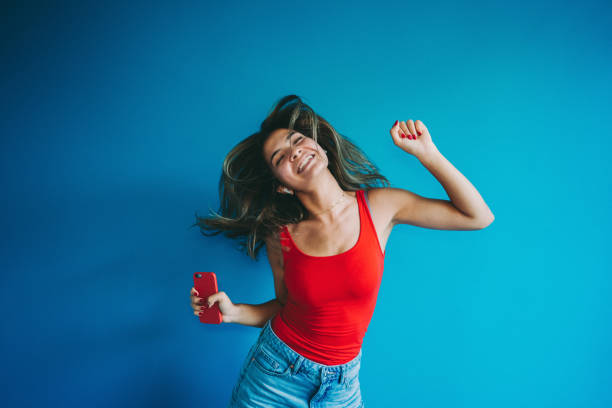istock Woman dancing against colored wall 1256868249