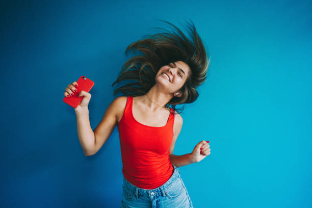 istock Woman dancing against blue wall 1256868417