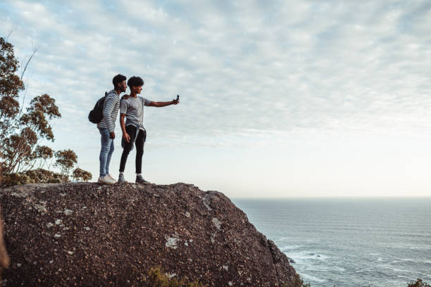 deux jeunes hommes prenant le selfie sur le bord de la falaise - panoramic landscape south africa cape town photos et images de collection