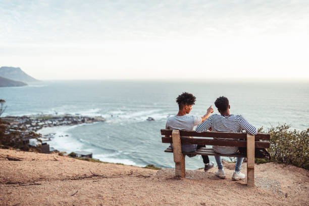 istock Two friends resting on the bench and enjoying the view 1256869583