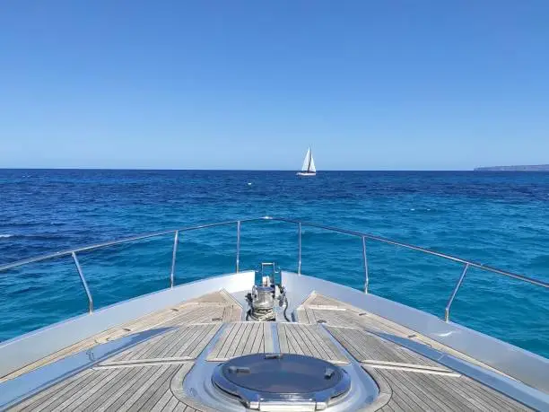 Photo of View if yacht bow sailing in turquoise water in Ibiza, Spain
