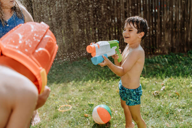 istock Brothers playing with water in the yard 1256870876