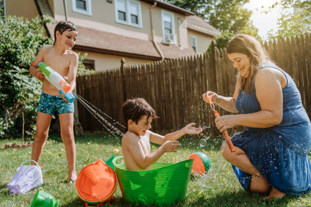 istock Brothers playing with water in the yard 1256870887