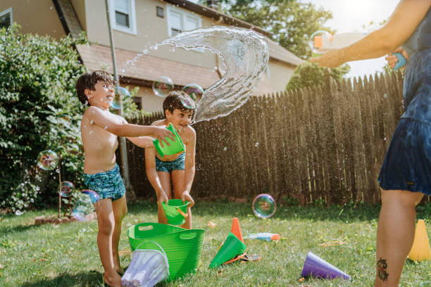 istock Brothers playing with water in the yard 1256870924