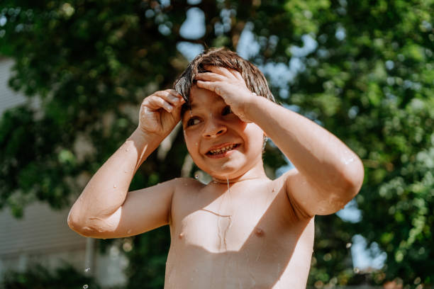 istock Brothers playing with water in the yard 1256870946