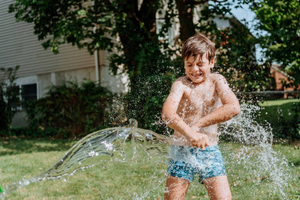 istock Brothers playing with water in the yard 1256870972