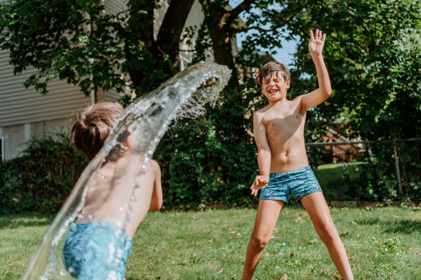 istock Brothers playing with water in the yard 1256870988