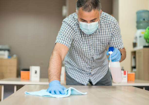 istock Man cleaning and disinfecting the office 1256871938