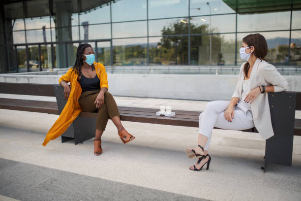 istock Businesswomen talking outdoors with social distancing 1256876200