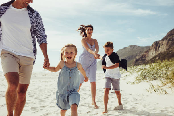 istock Kids having fun with parents on beach vacation 1256877392