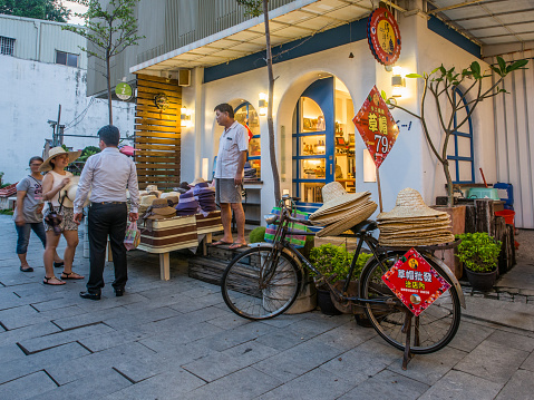 Tainan, Taiwan - October 10, 2016: Typical local bazaar in Taiwan with lots of local products and straw  hats on the bicycle