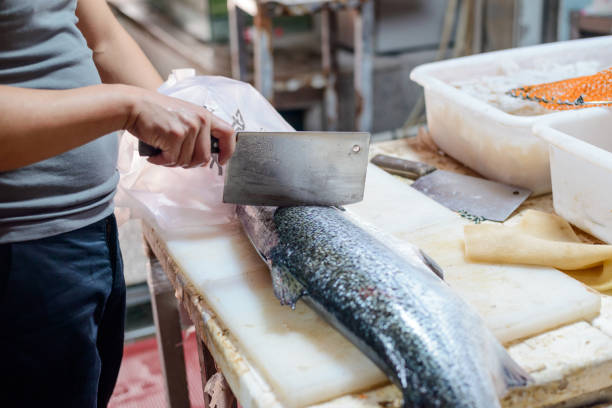 istock Worker steaking a fish with a cleaver knife 1256885876
