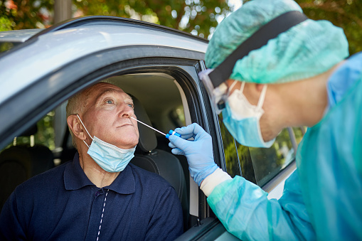 Senior Man Getting Nasal Swab Test at Drive-Thru Site photo