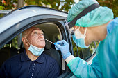 Senior Man Getting Nasal Swab Test at Drive-Thru Site