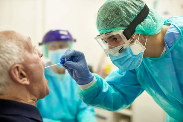 istock Male Nurse Taking Throat Swab for Diagnostic Testing 1256886008
