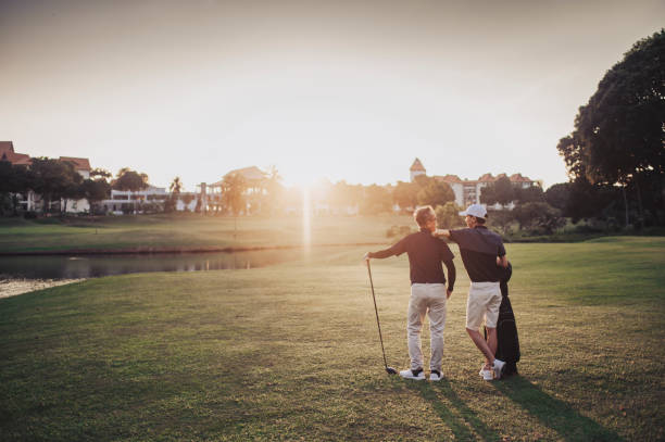 an asian chinese senior man golfer carrying his golf club on his shoulder and looking at the view in golf course - retirement golfer happiness relaxation stock-fotos und bilder