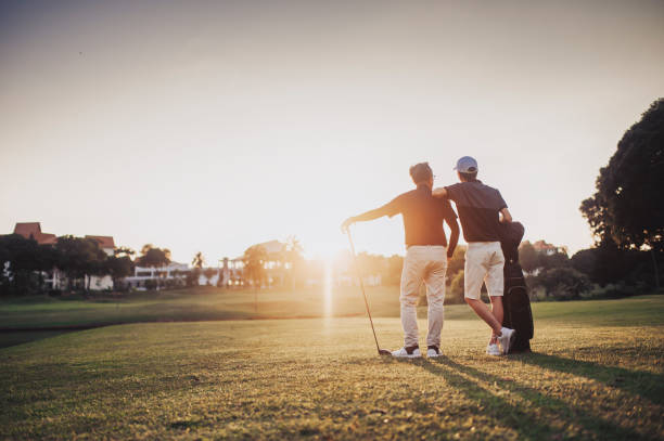 un asiático chino senior hombre golfista llevando su palo de golf en su hombro y mirando la vista en el campo de golf - retirement golfer happiness relaxation fotografías e imágenes de stock