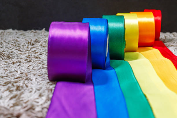 ribbons in the color of the lgbt rainbow flag in bobbins are rolled out on the carpet using how to celebrate homosexuals, gay, lesbian and concepts ribbons in the color of the lgbt rainbow flag in bobbins are rolled out on the carpet using how to celebrate homosexuals, gay, lesbian and concepts rainbow flag photos stock pictures, royalty-free photos & images