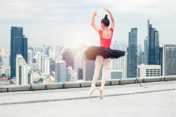 istock Asian ballerina dancer girl practicing ballet dancing on rooftop with skyscraper city view, adorable child dancing in ballet 1256896813