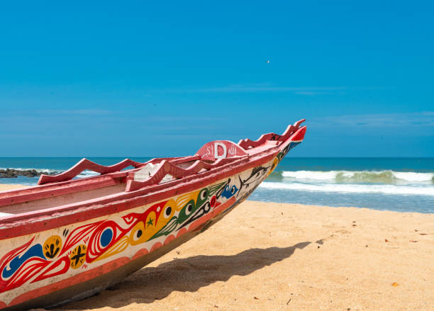 ビーチでカラフルなフィッシャーボート、ソモネ、セネガル - africa blue cloud color image ストックフォトと画像