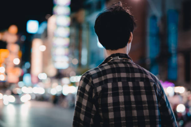 istock Young man holding cell phone waiting for car 1256899332