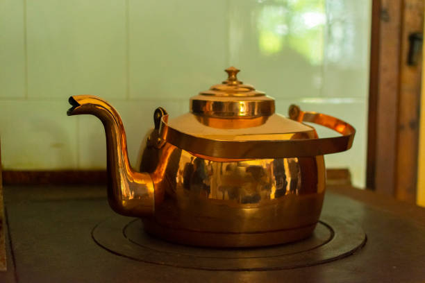 large antique copper teapot on the stove