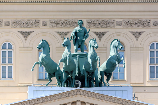 Russia, Moscow - June 21, 2020: View of The Quadriga sculpture located on The Bolshoi Theatre building, which holds ballet and opera performances. Clear blue sky. Russian culture theme.