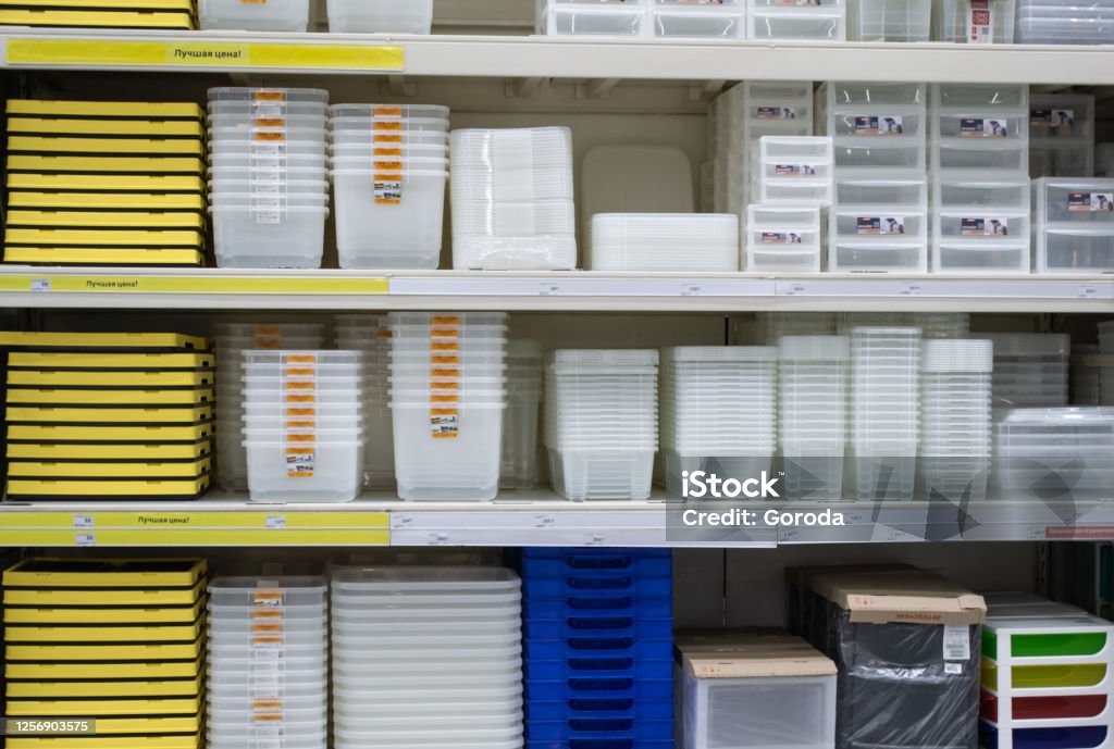 Stacked of transparent, white, blue and yellow plastic boxes for storage. Inside the warehouse in store Plastic Container Stock Photo