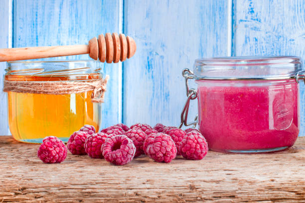 istock Still life with ripe raspberries scattered on a wooden board. 1256903836