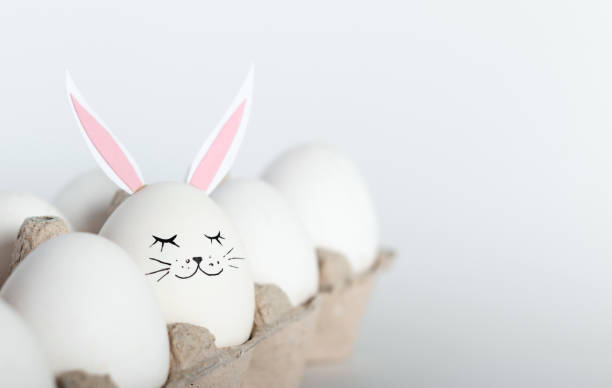 istock Creative concept photography. White eggs with hare ears and face. Happy Easter holiday concept. Minimalism. 1256904941